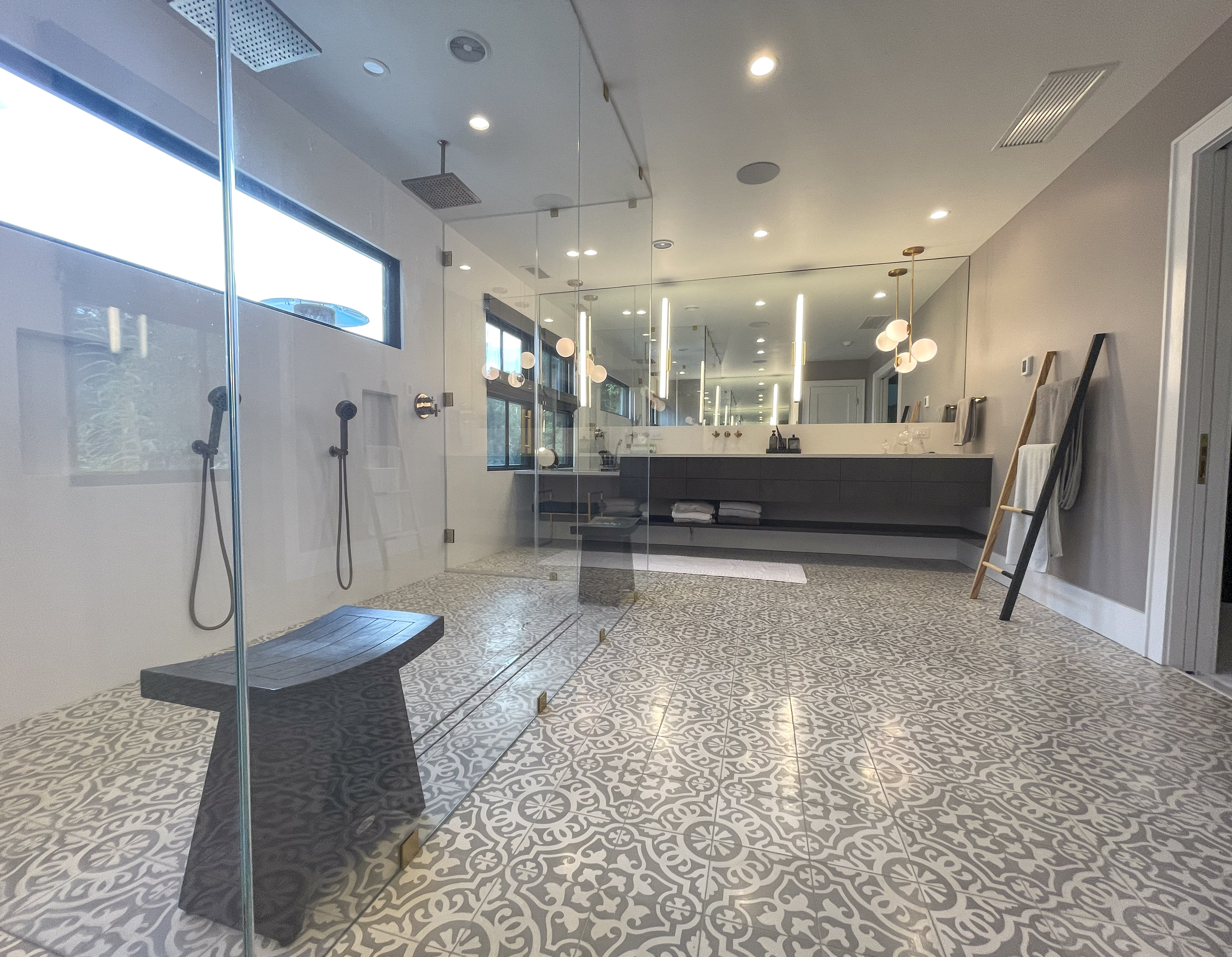 Primary bathroom glass shower with dual vanity and mirrored wall