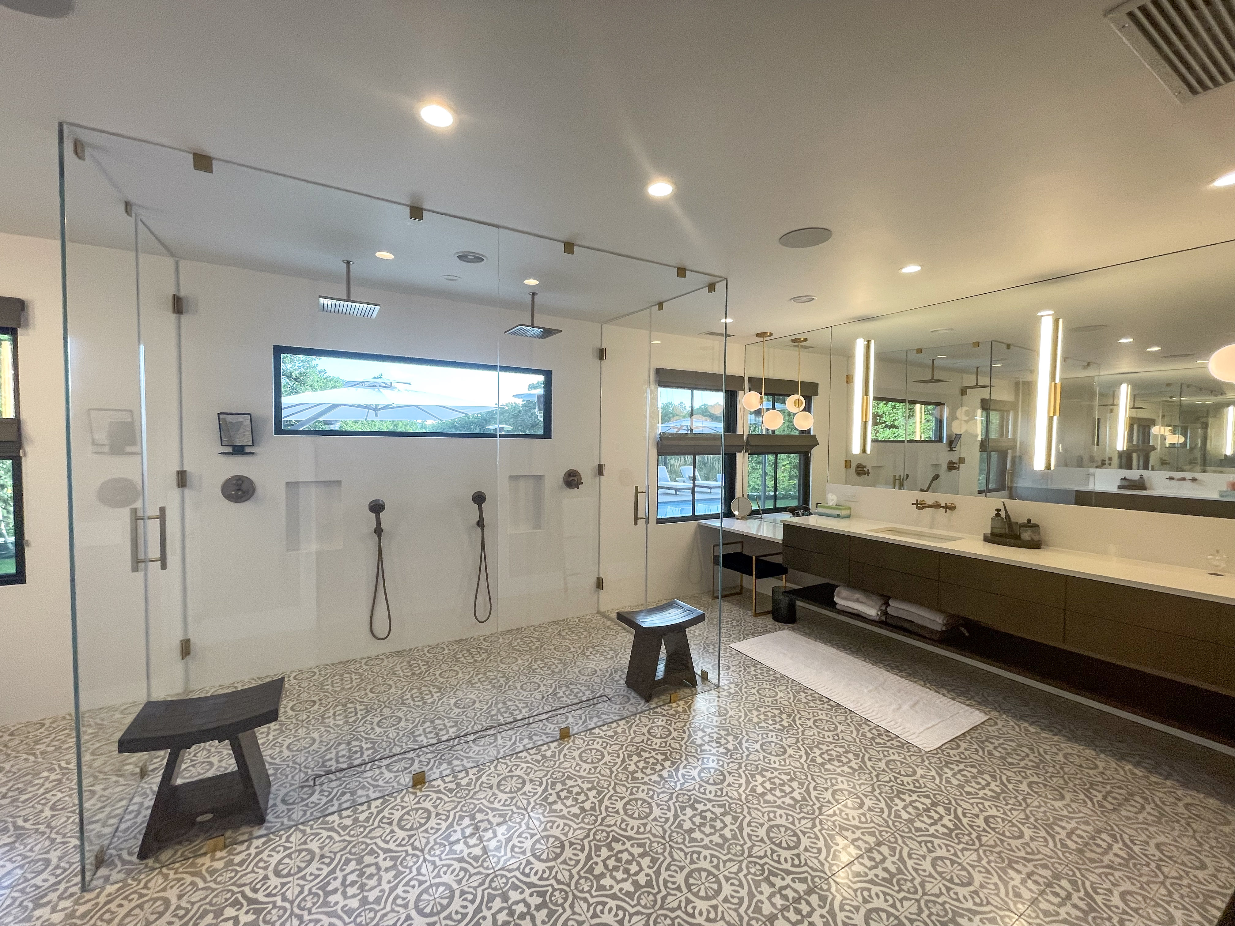 Primary bathroom with walk-in glass shower overlooking the pool