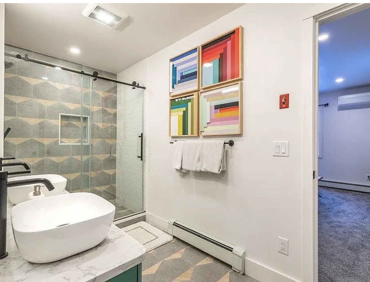 Bathroom with colorful geometric tile and framed art