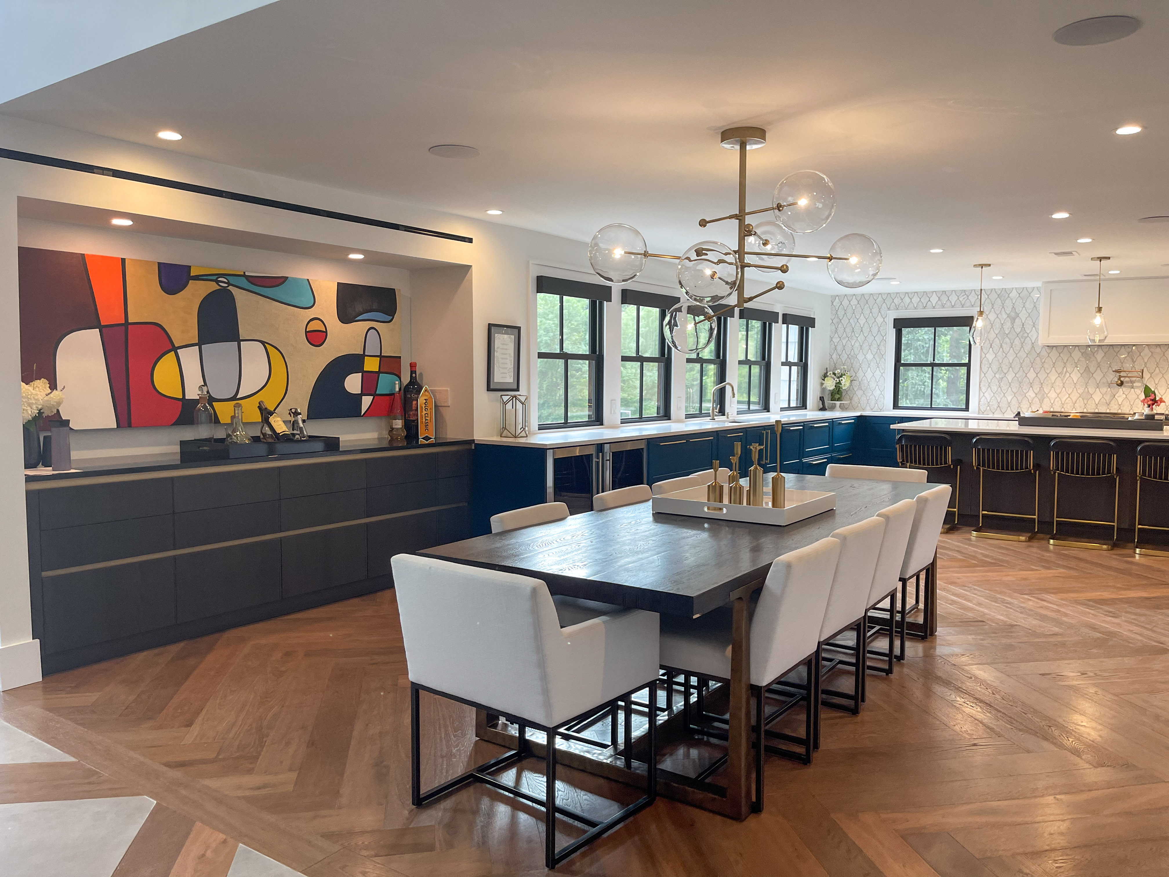 Open dining area with statement chandelier and abstract art wall