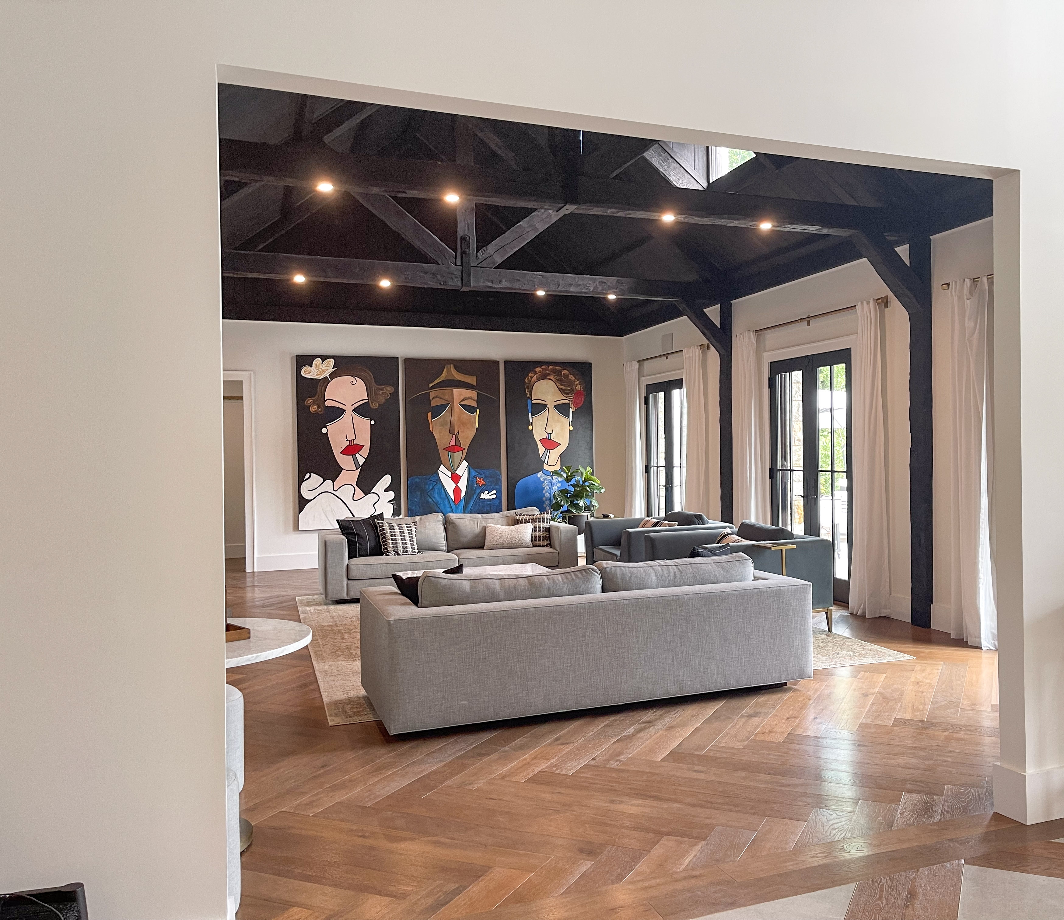 Great room with gallery wall art above grey sofas
